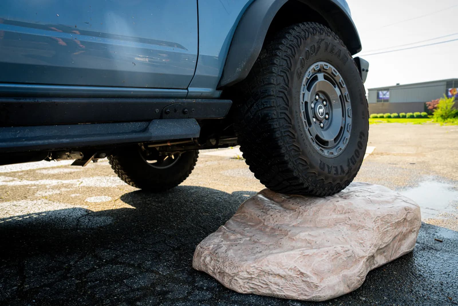 A Ford Bronco climbing the Boulder Buddy display rock